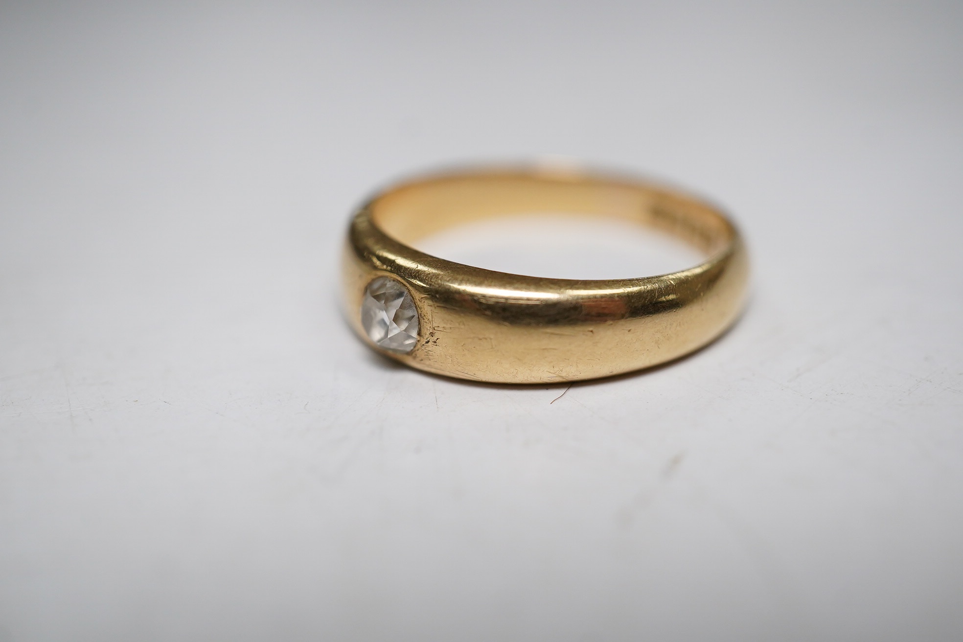 A late Victorian 18ct gold and single stone gypsy set diamond ring, size P, gross weight 5.3 grams. Condition - fair